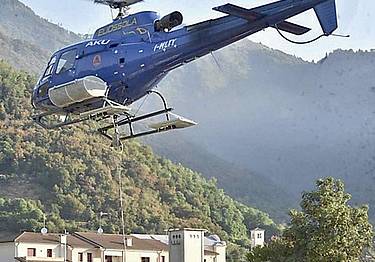 Un elicottero che raccoglie acqua da una cisterna a Miane
